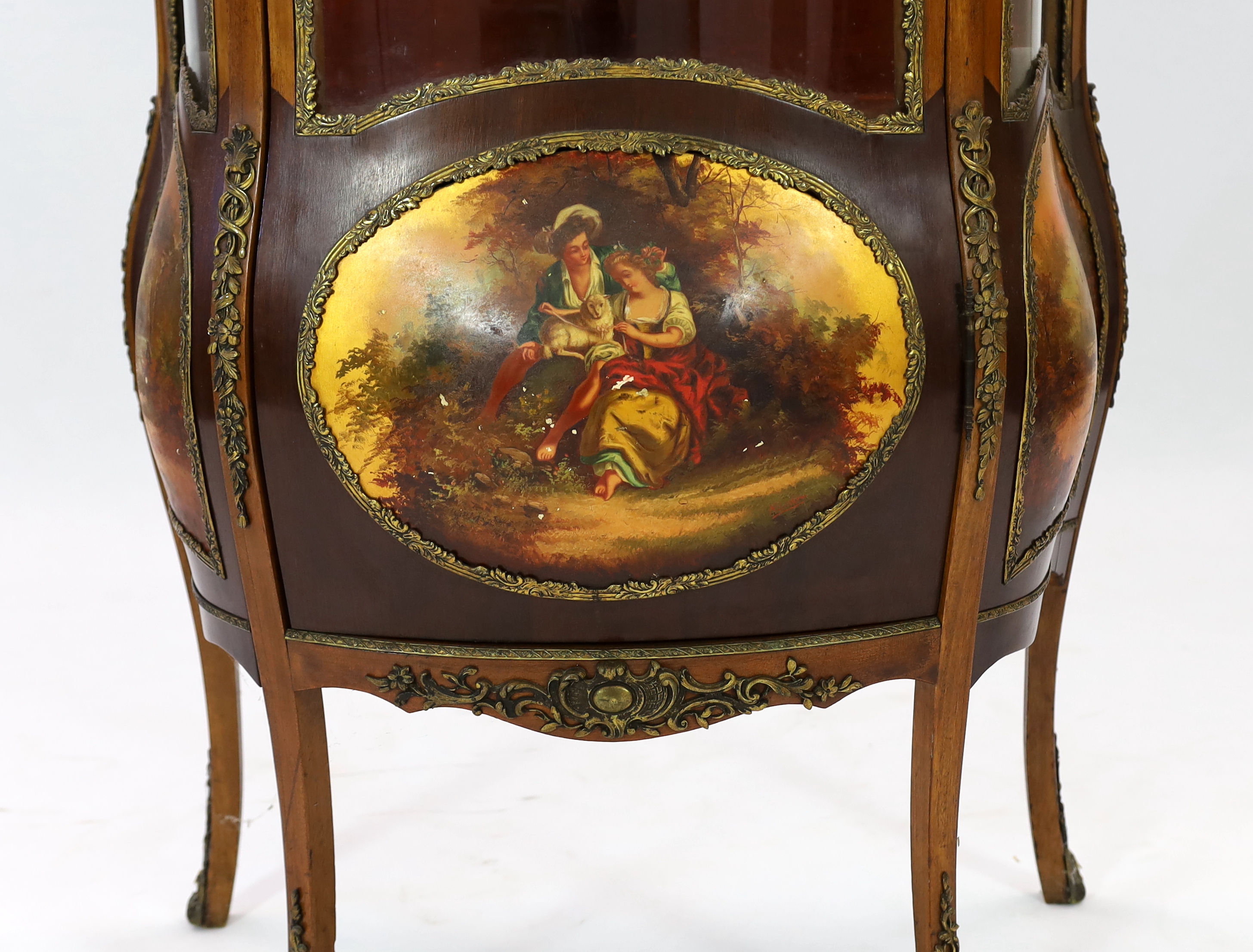 A French Vernis Martin style walnut vitrine, of bombé form with ormolu mounts, three quarter glazed door, lower panels, painted with scenes after Boucher and signed 'Albertine', on cabriole legs, 78cm wide, 42cm deep, 17